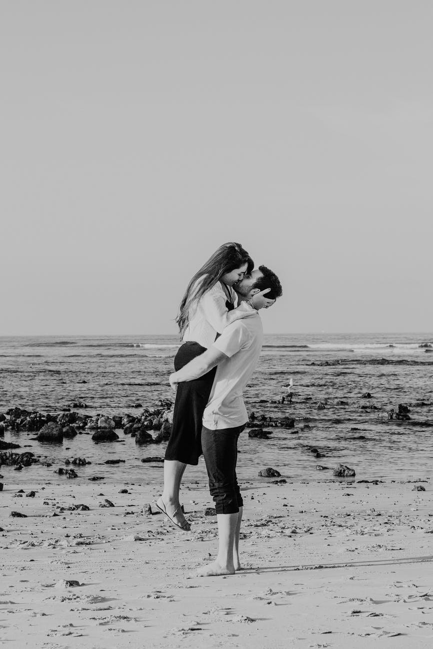 loving couple embracing and kissing passionately on seacoast