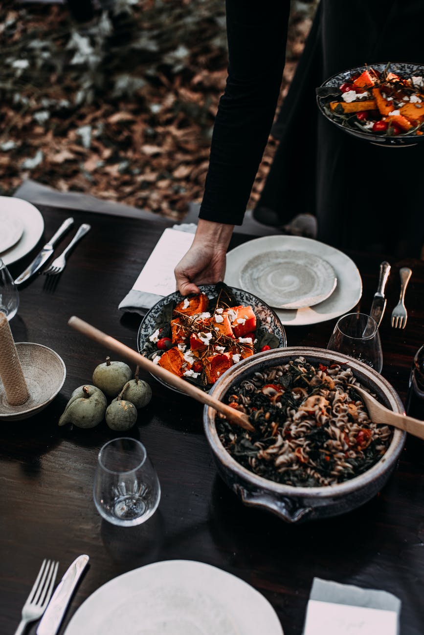 woman serving table with dishes for picnic